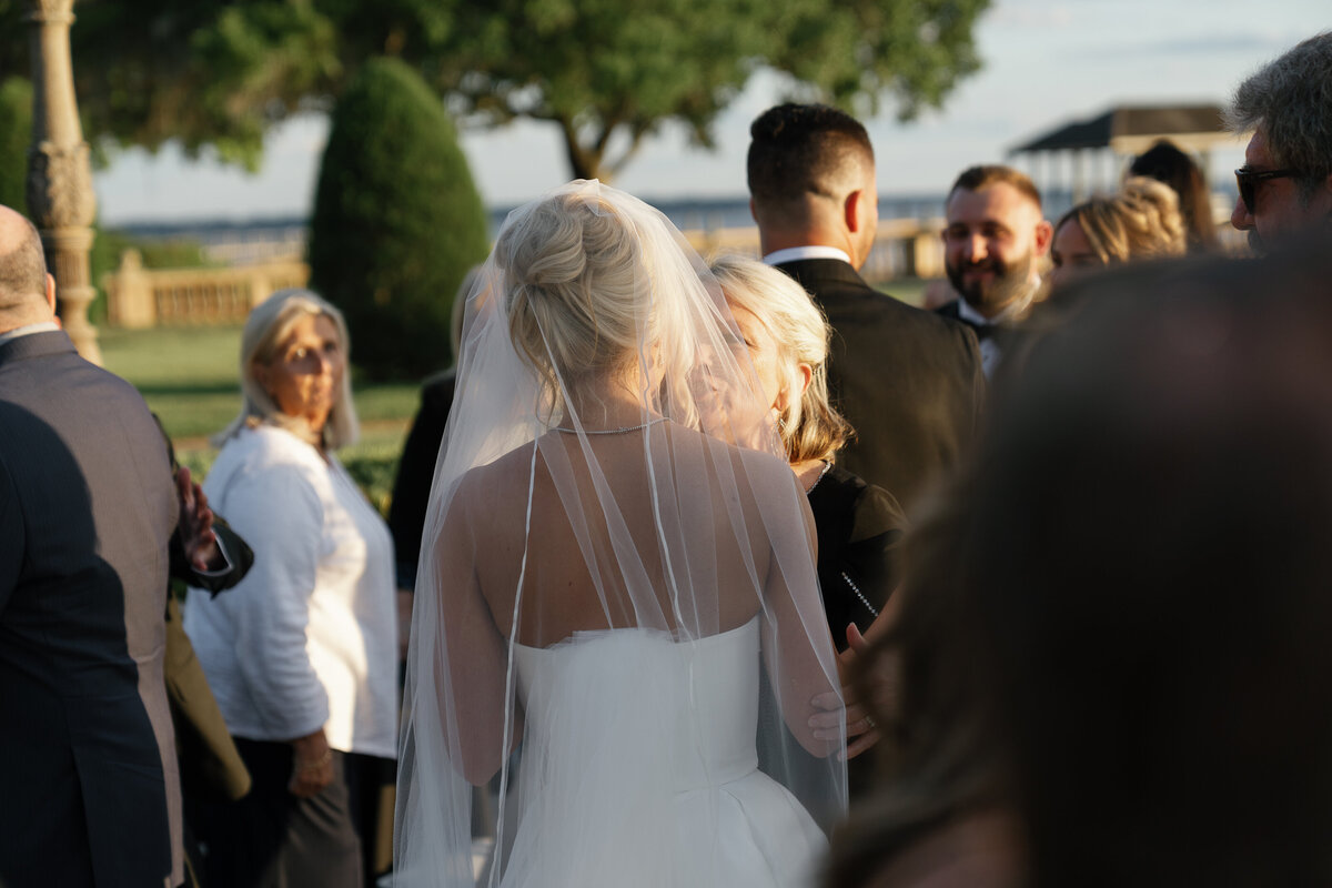 Bride talking and embracing with guest at cocktail hour by jacksonville wedding photographer, Shelby Ann Photos
