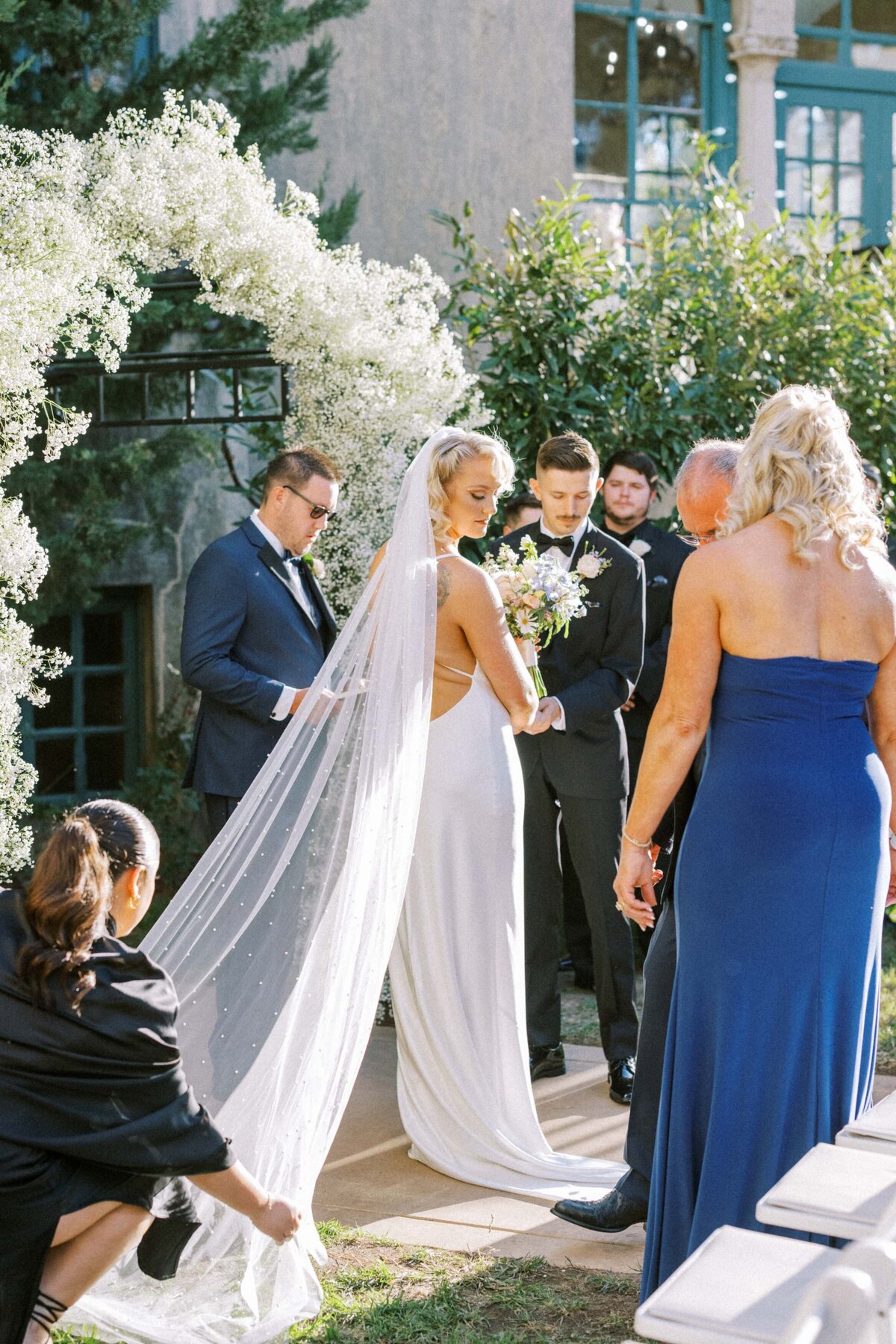 bridesmaid-adjusting-veil-for-ceremony
