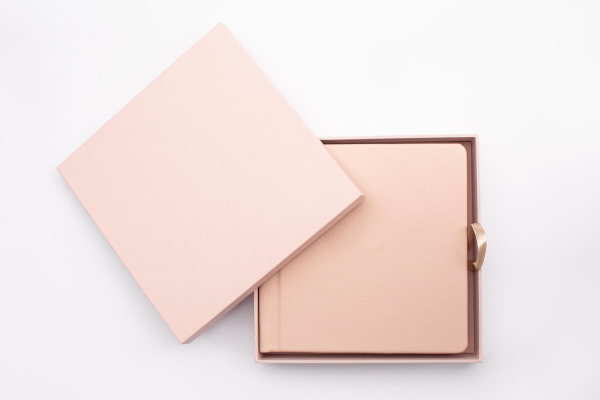 A pink photo album in its box. It is pictured on a white background.