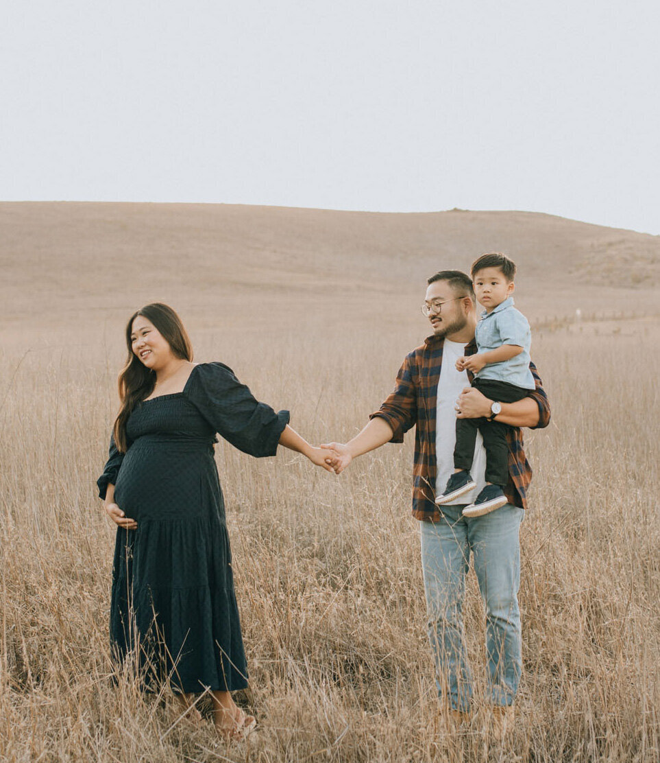 Family walking through a field during golden hour