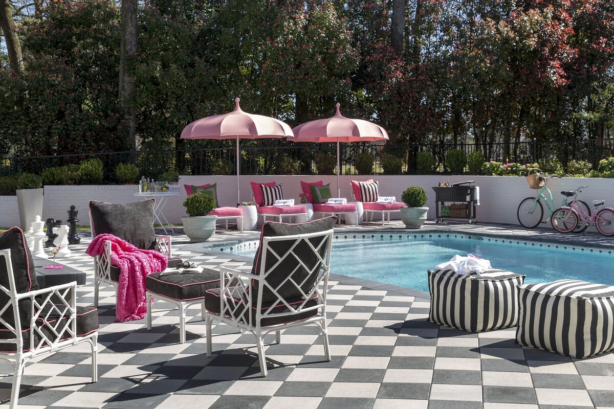 modern-outdoor-pool-design-checkered-patio-pink-umbrellas.