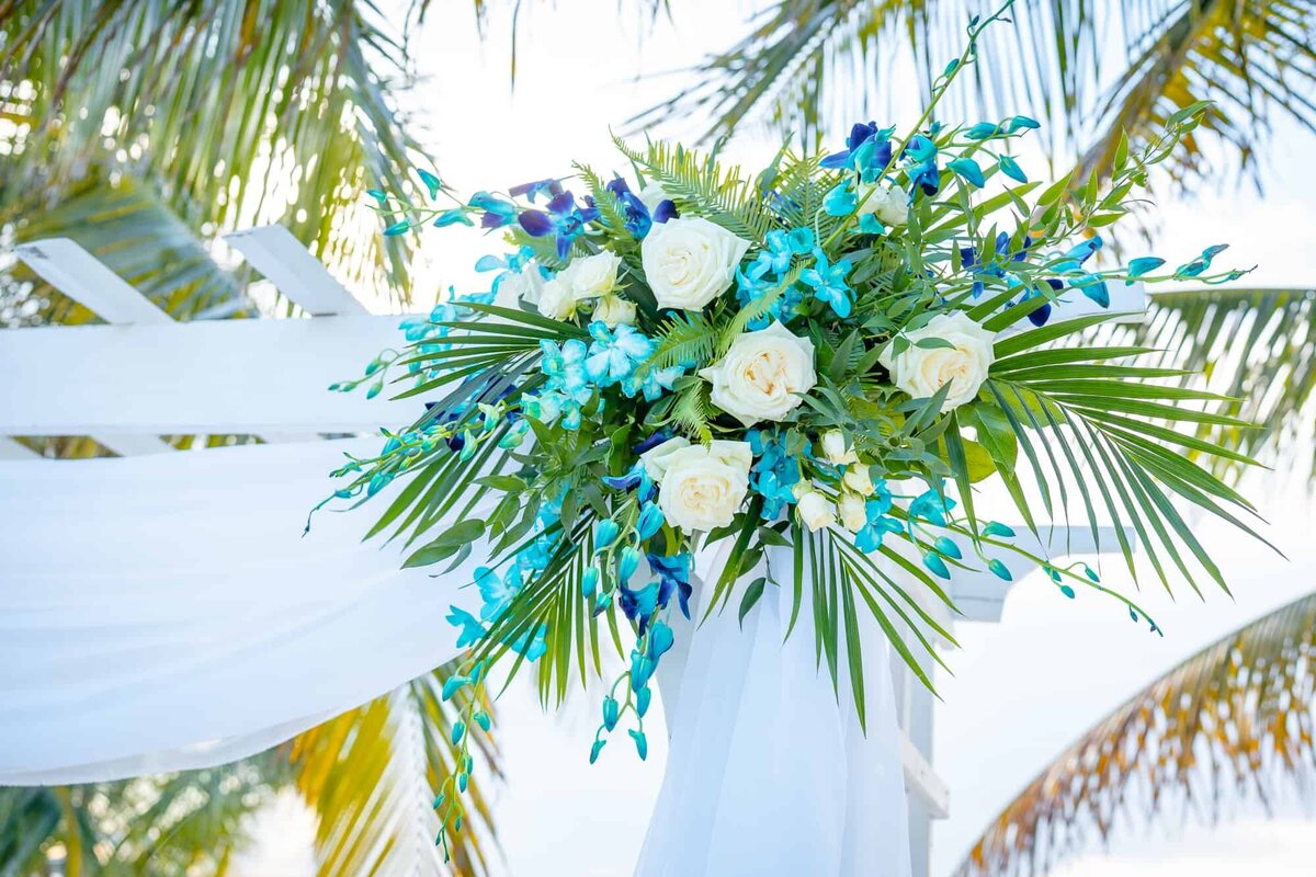Blue and green tropical floral decor on the wedding arch at Key Largo Wedding venue photographed by Key Largo photographer