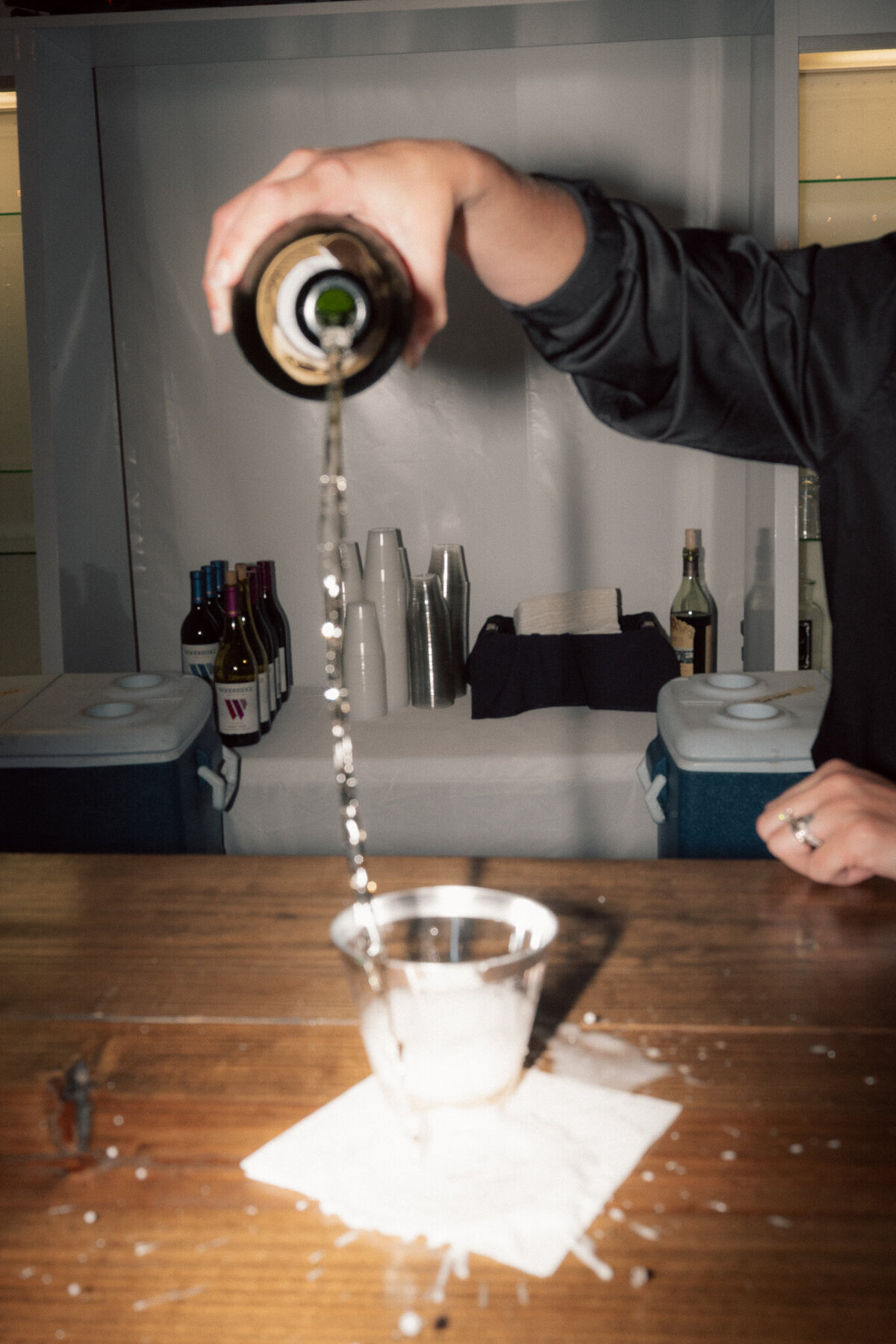 Champagne being poured into glass during lively wedding reception