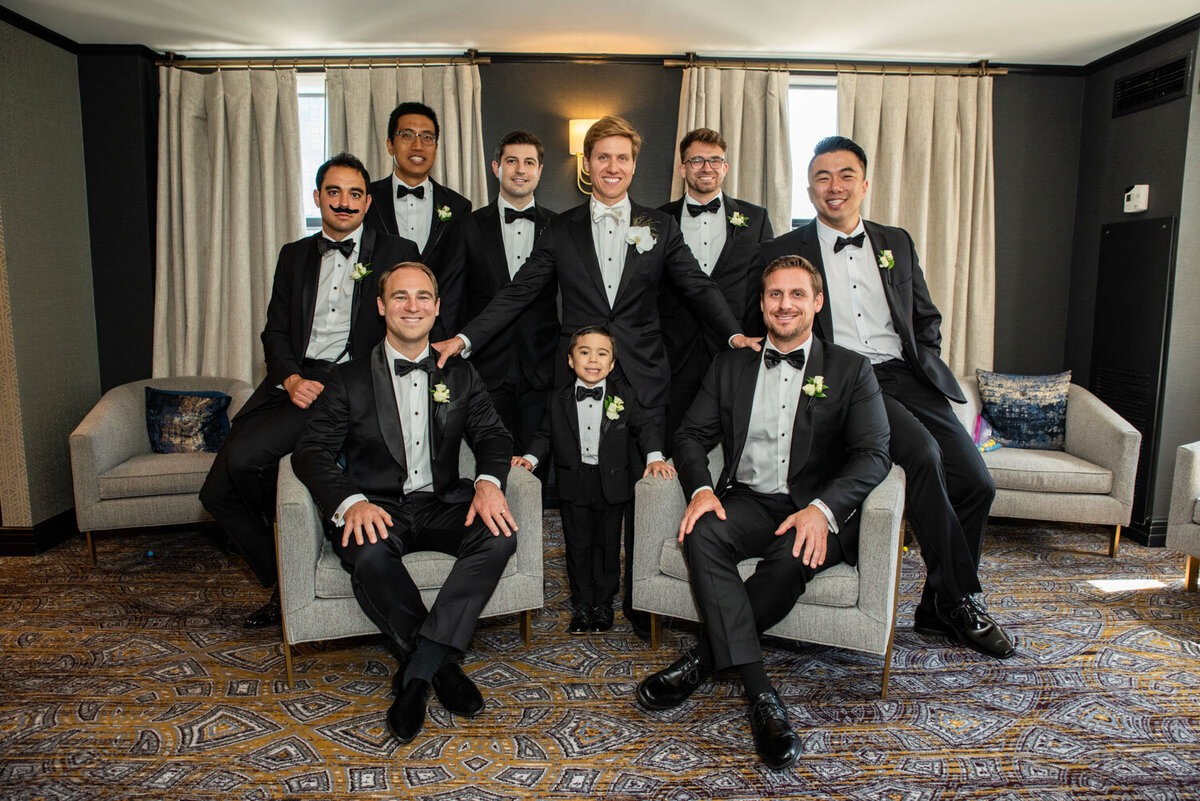 A group of men in tuxedos posing for a picture