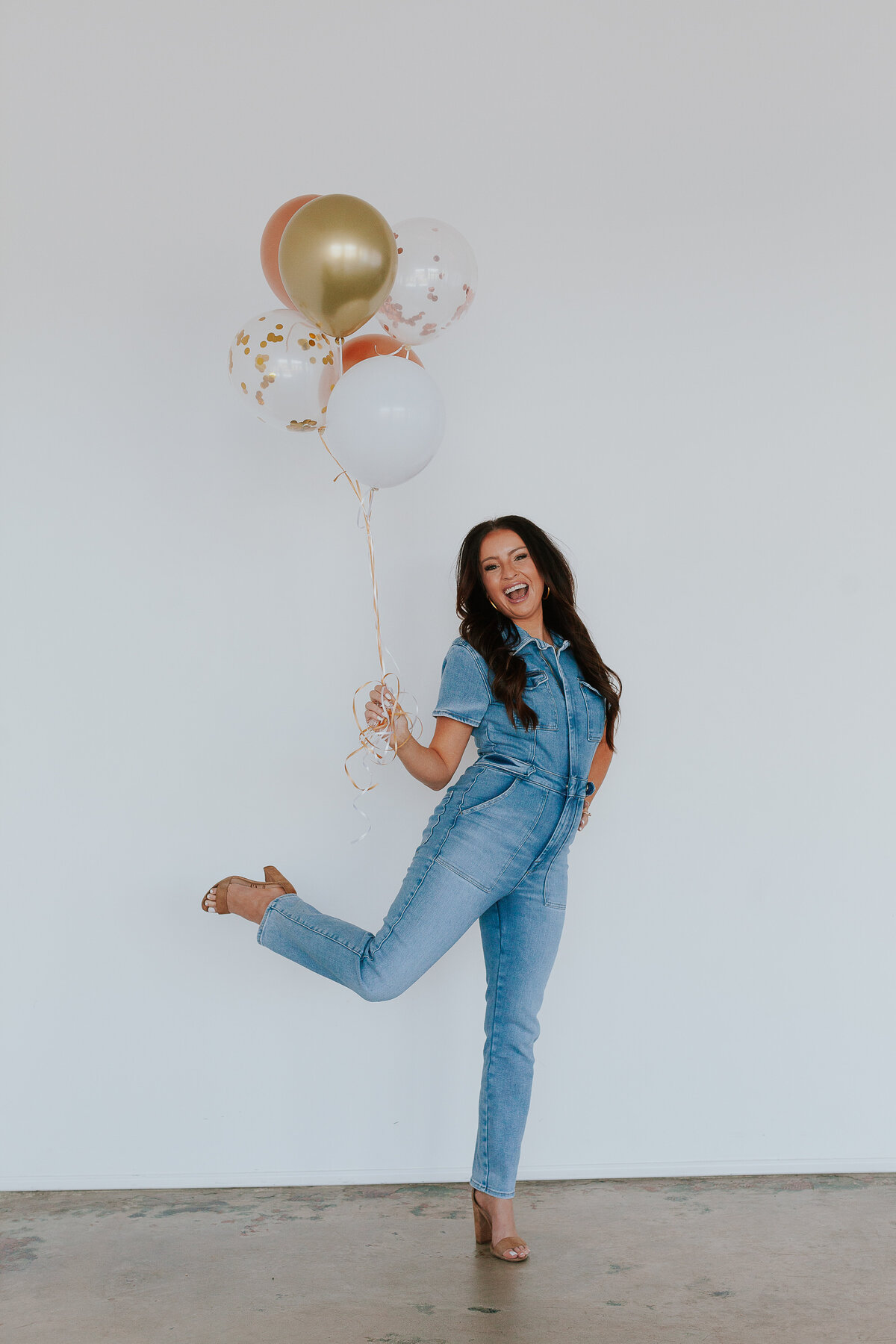 woman-celebrating-holding-balloons-kicking-up-heel-for-brand-session-the-frame-charlotte