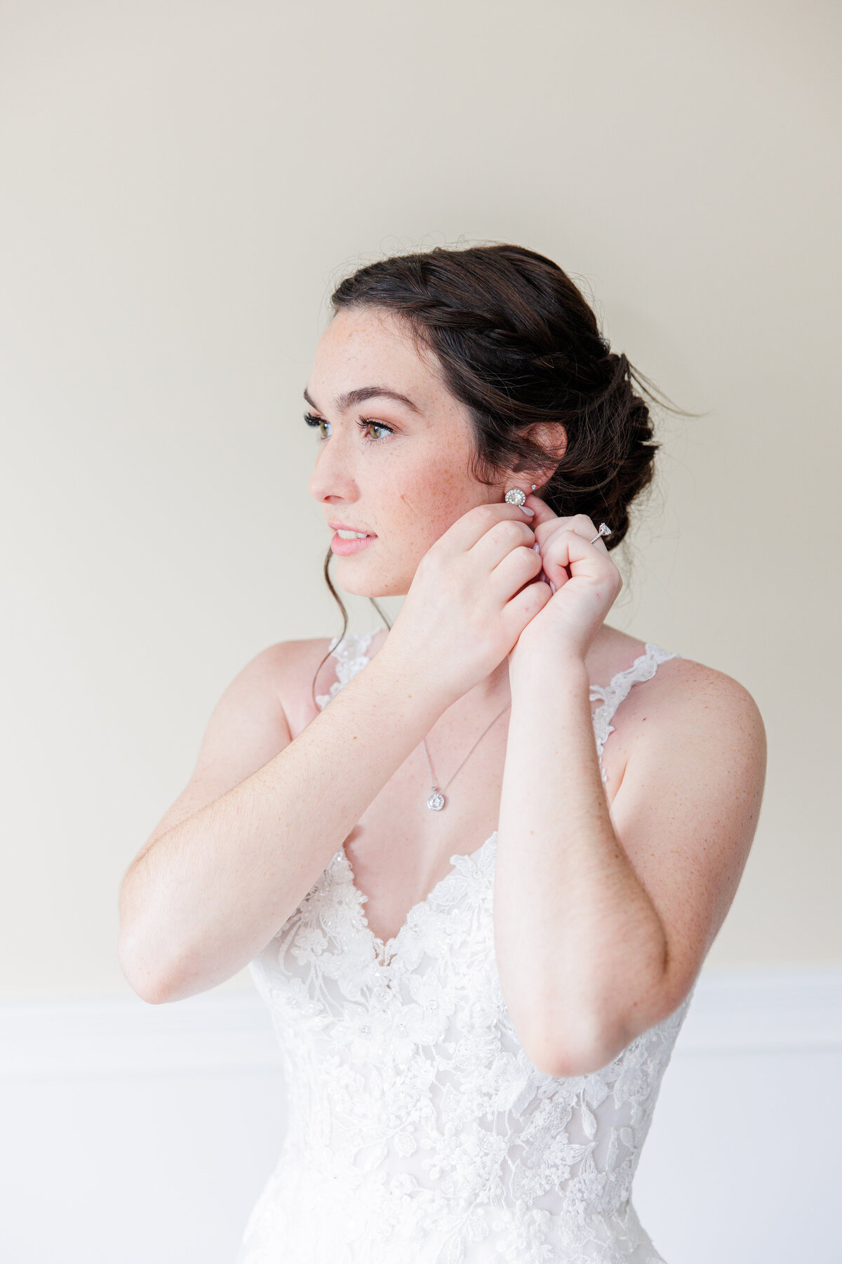 Bride putting in her earrings during her Boston bridal pictures