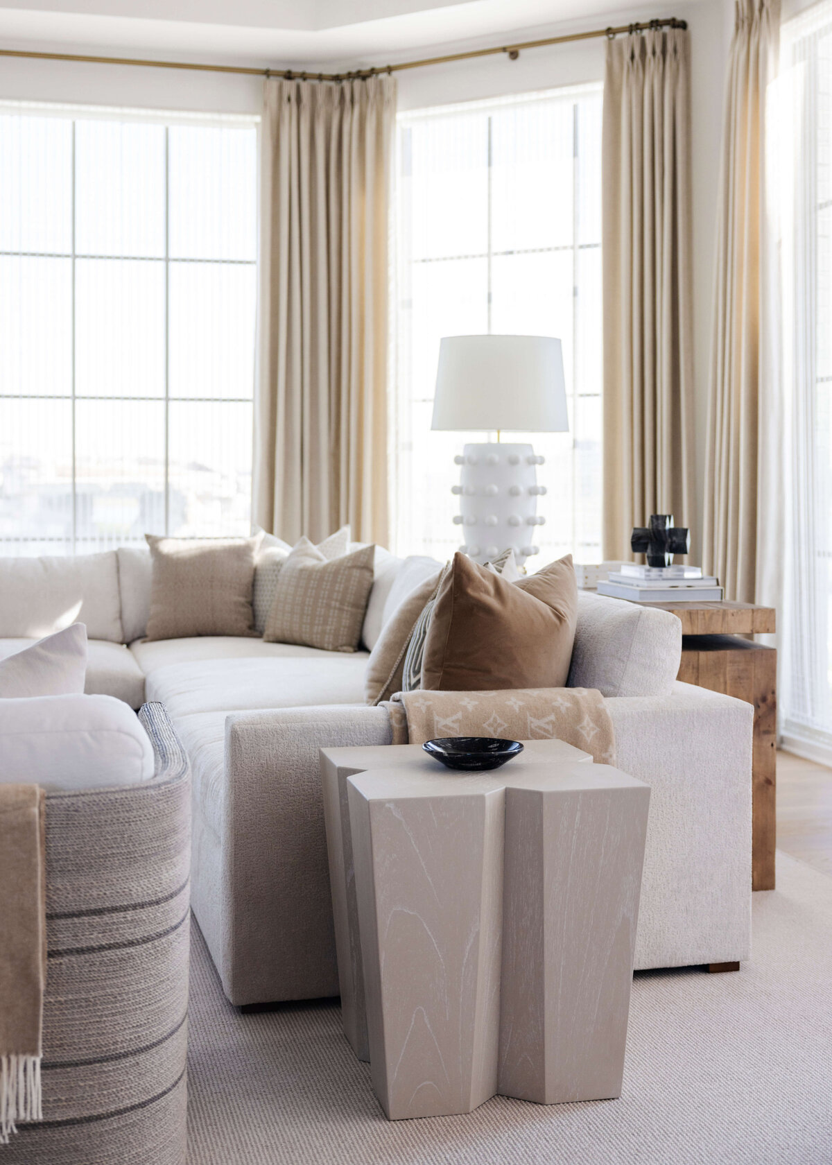 oyster creek studios hughes light wooden accent table in living room with tan curtains and light brown sofa