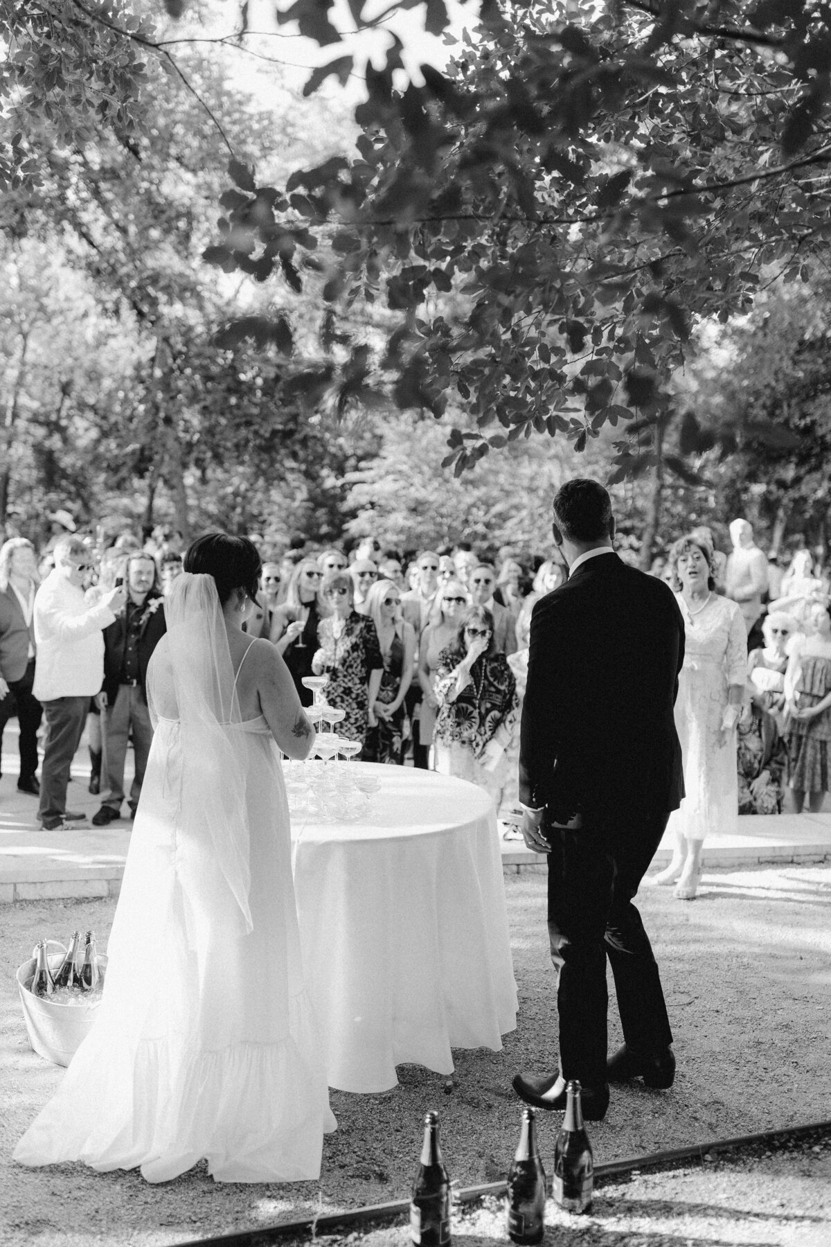 Bride and groom standing next to champagne bottles