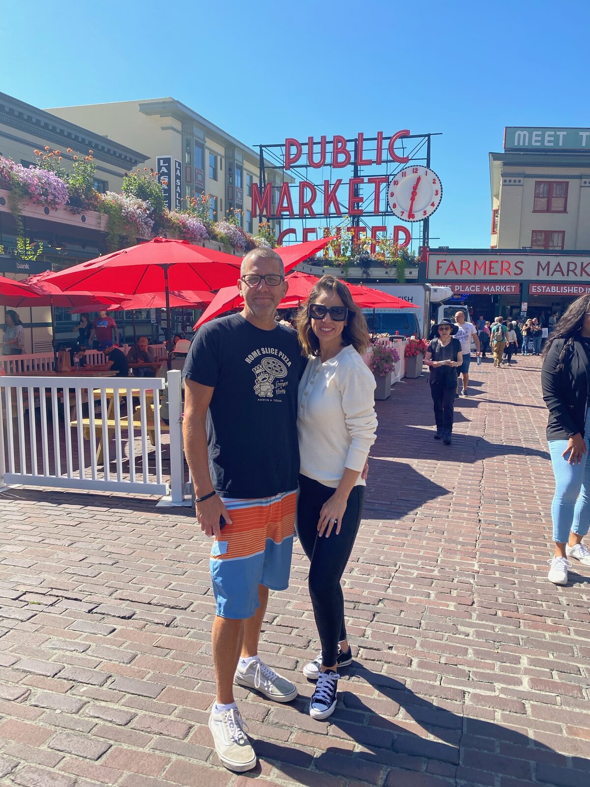 Couple posing in front of the Market in Seattle