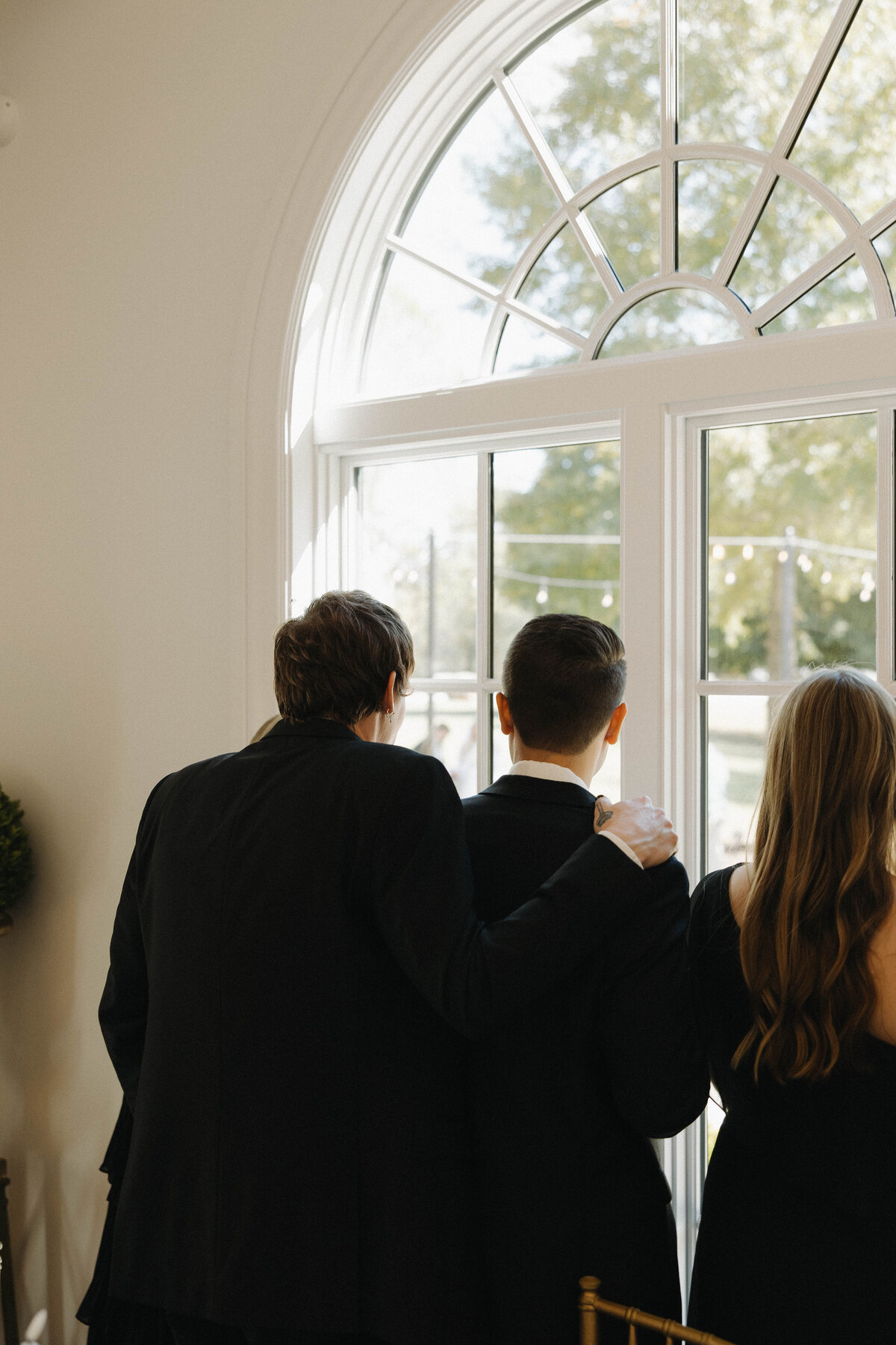 Friends and family watching first look with bride and groom from inside the venue