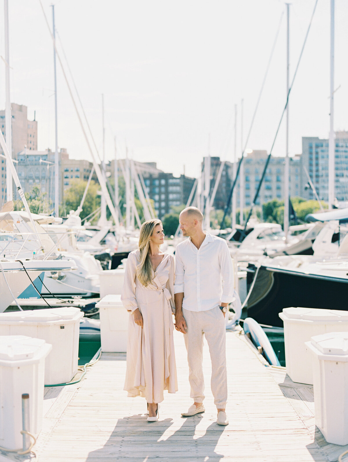 Bride and groom looking at one another and holding hands on a dock in Chicago photographed by Arielle Peters Photography