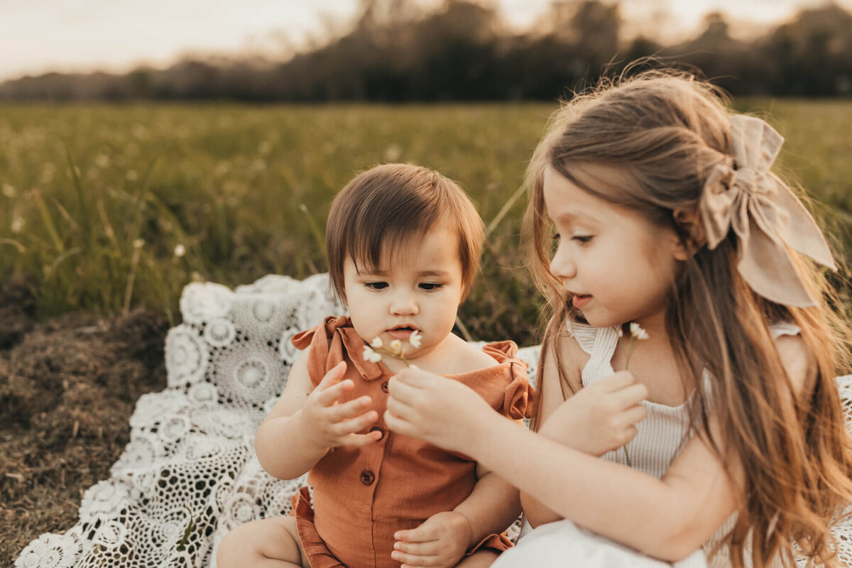 big sister hands her flowers