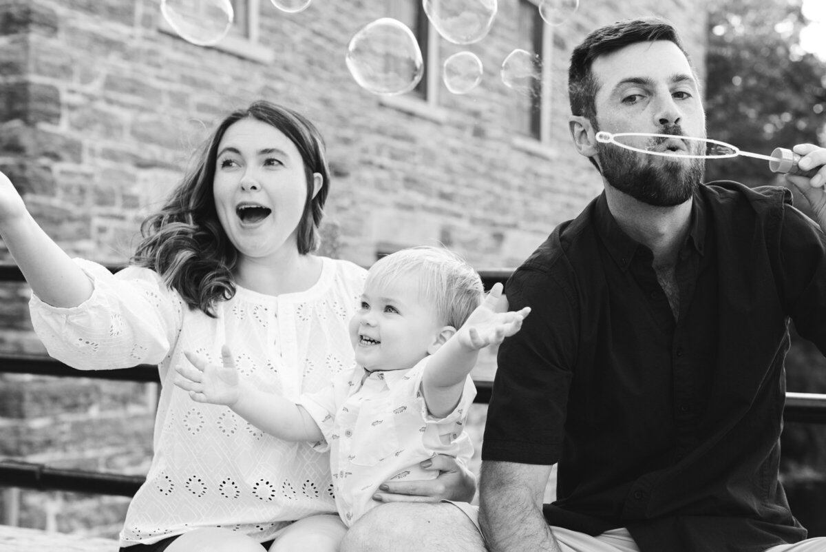 black and white photo of family blowing bubbles