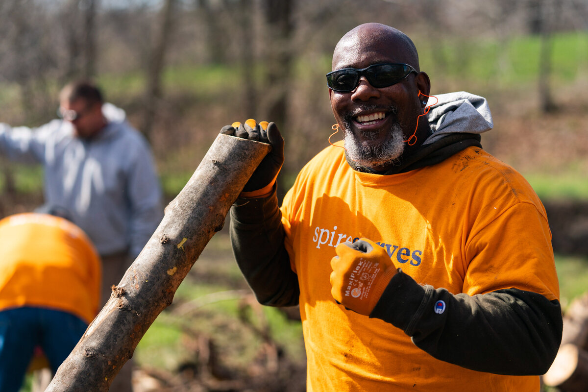 kansas-city-marketing-photography-people-0106-man-holding-tree-stump-smiling