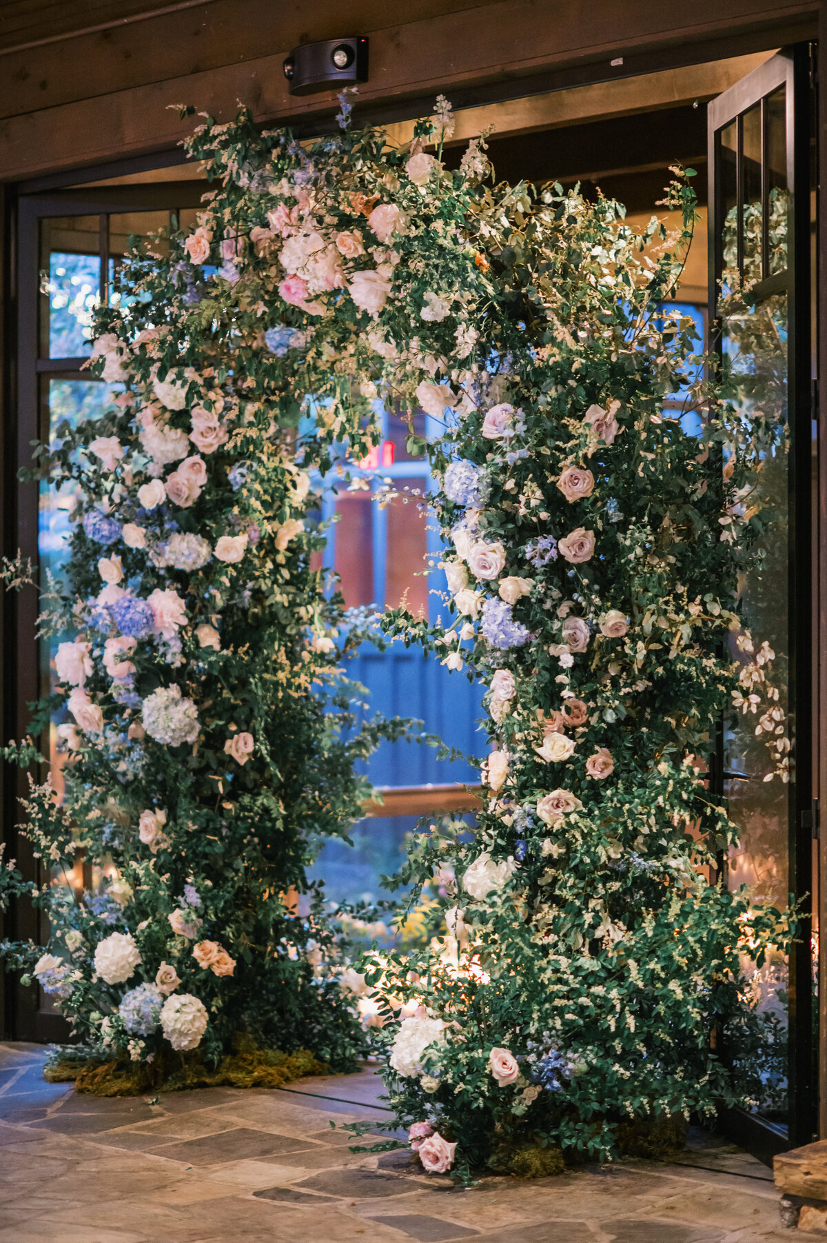  Romantic floral arch of roses, hydrangeas, and greenery at the reception entrance at Old Edwards Inn in Highlands, North Carolina.