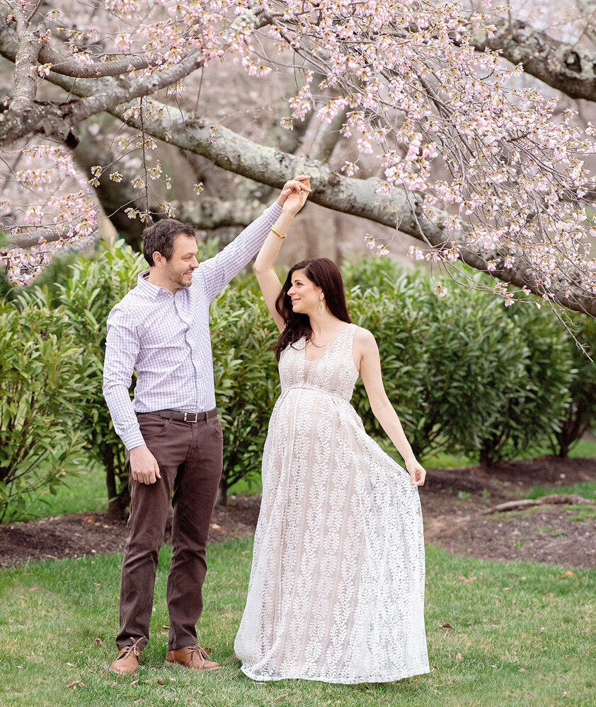 Maternity session of couple posing under flowers
