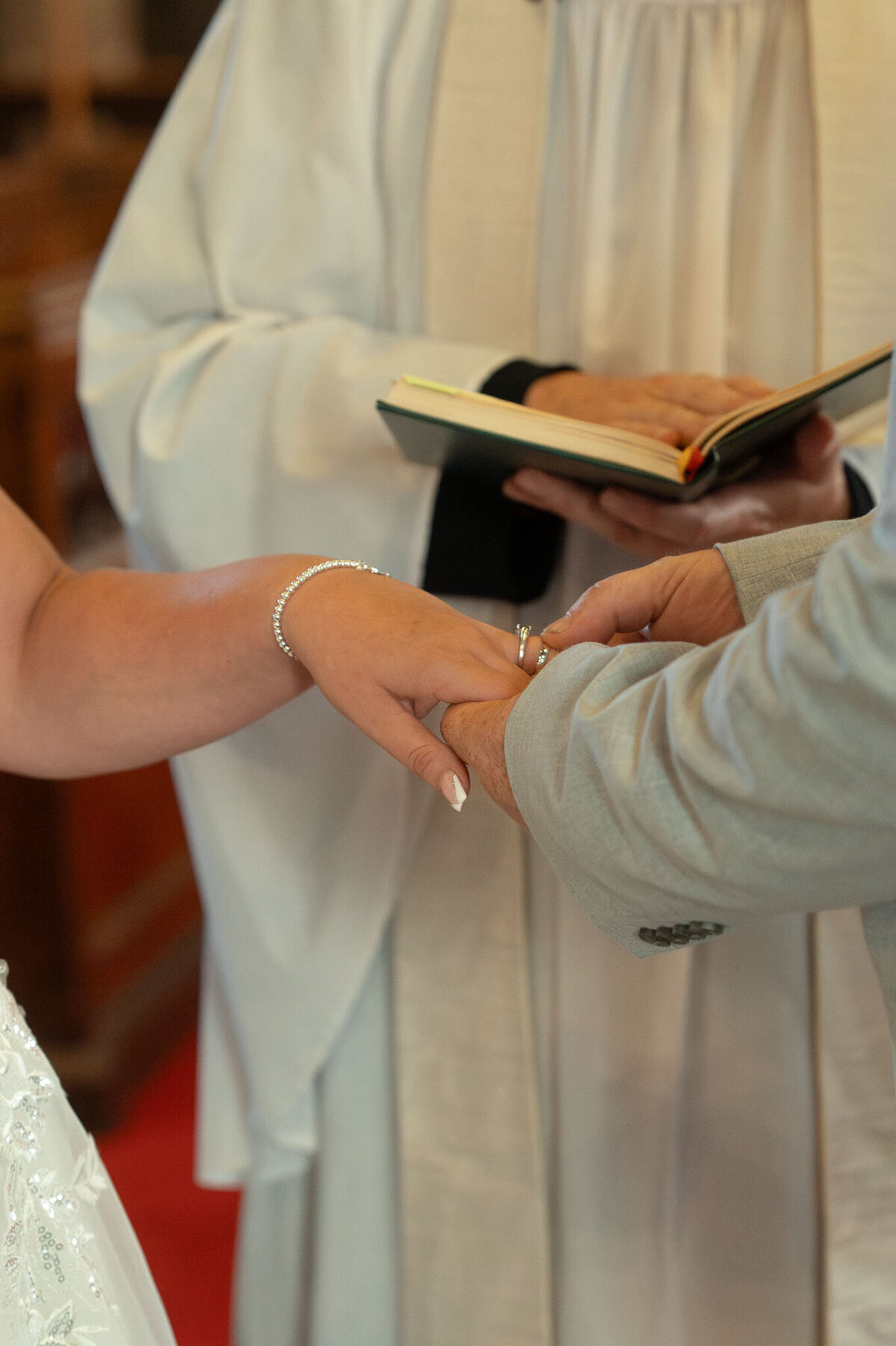 Bride and groom exchanging wedding rings during church ceremony – Manchester photographer.