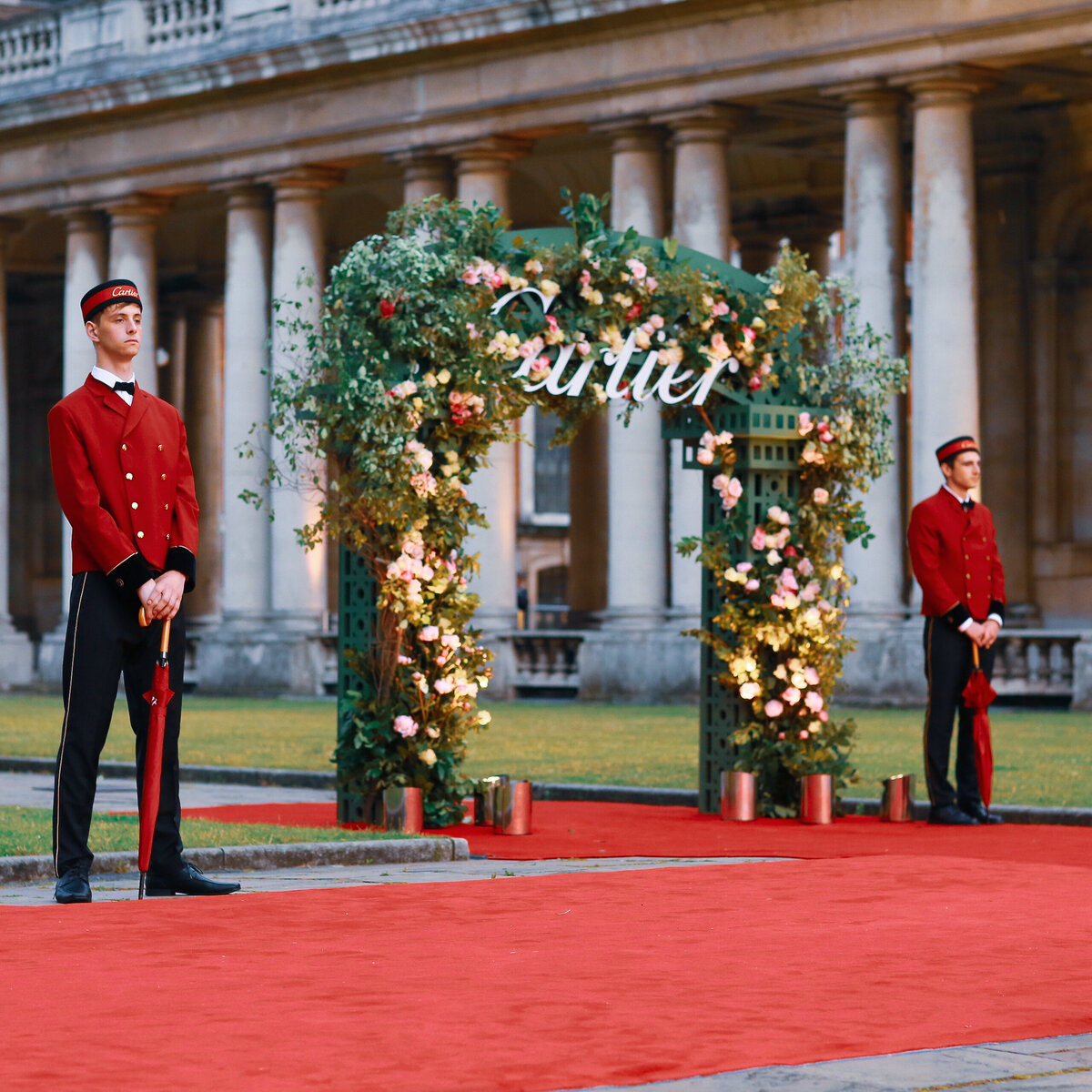 A red carpet with a floral arch at the Old Royal Naval College in London for an event for Cartier.
