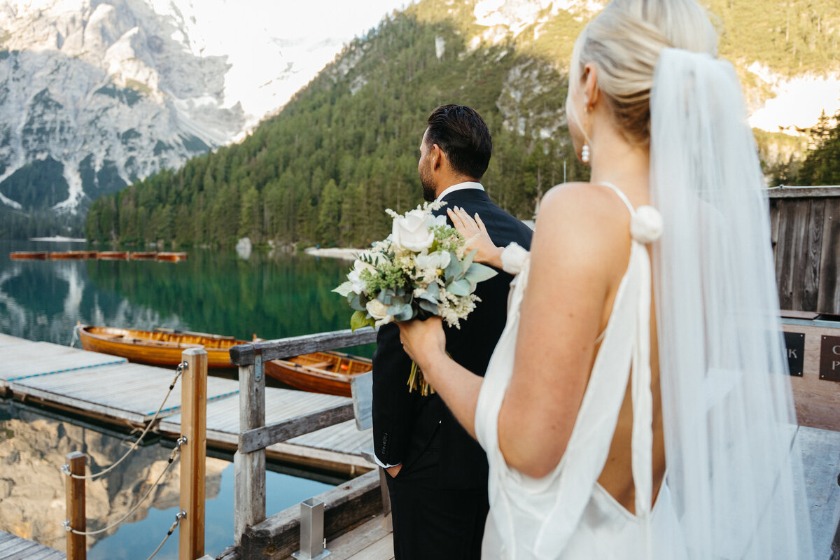 Bride holding bouquet on boathouse deck before first look