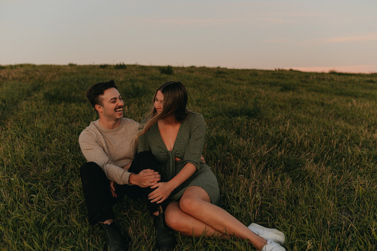 couple lying in grass at sunset