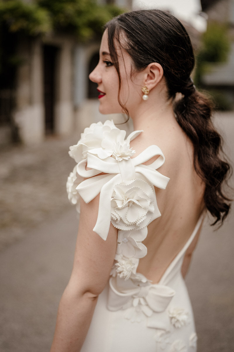 Détail élégant de la robe de la mariée, photographié dans un village suisse au bord du lac Léman, lors d’un mariage en duo photo et vidéo.