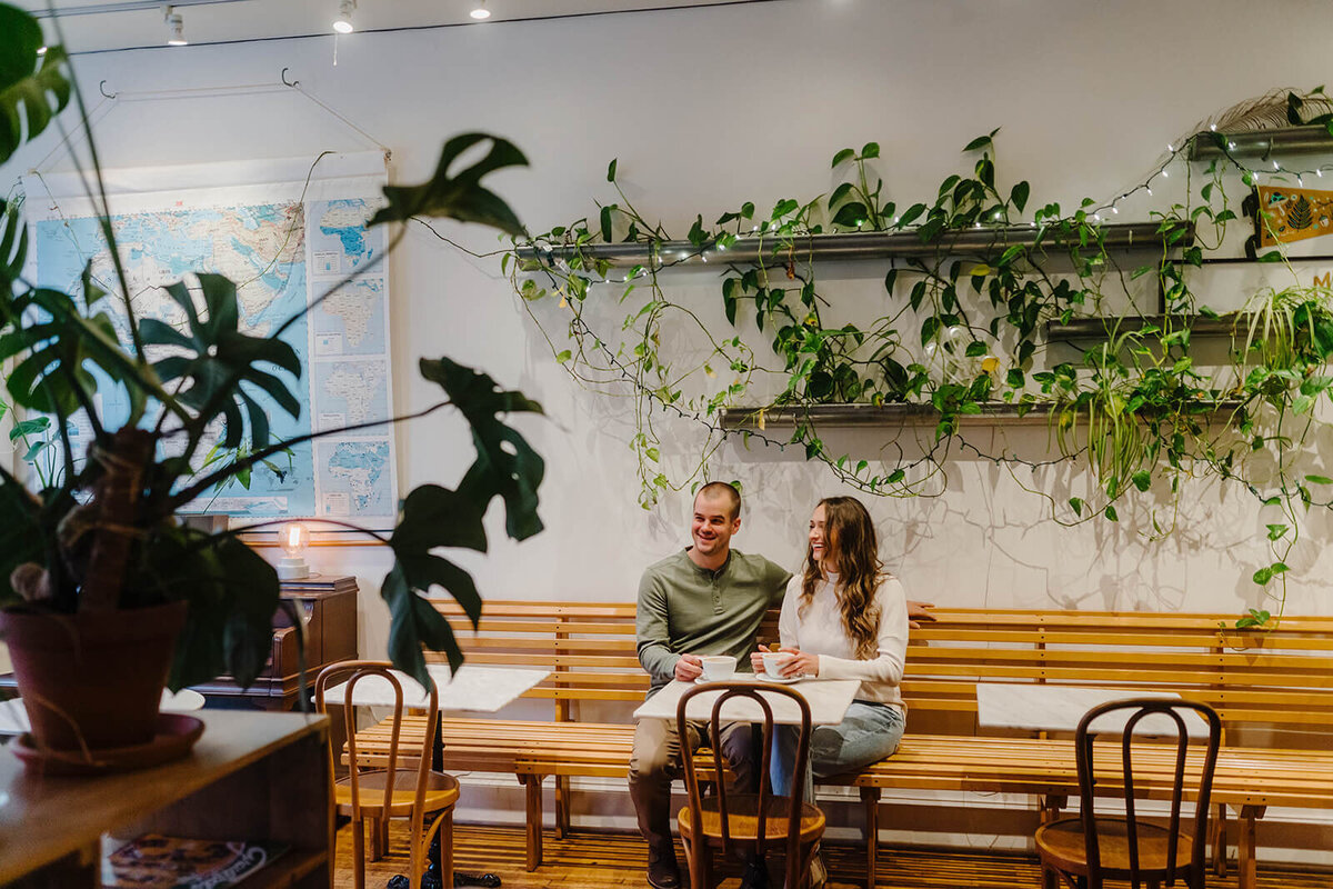 Couple sat together a coffee shop at Finger Lakes engagement session