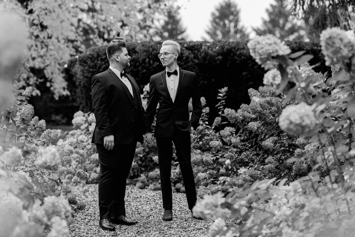 grooms in classic and stylish suits in garden at Greencrest Manor in Michigan