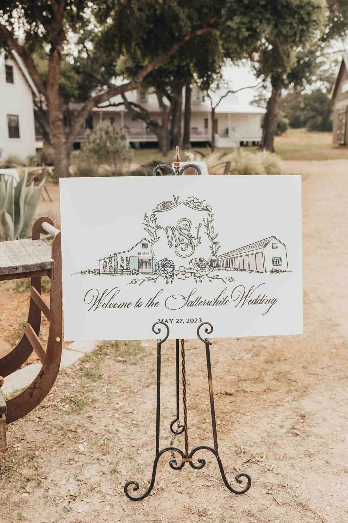 posterboard of drawing of the venue and couples name sits on an easel.