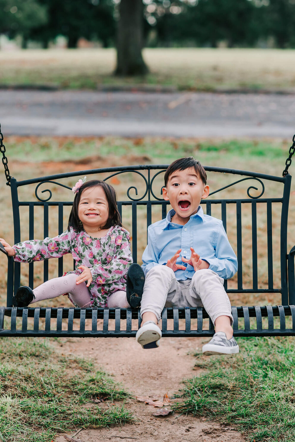 Children showing exuberance sitting on a swinging bench together