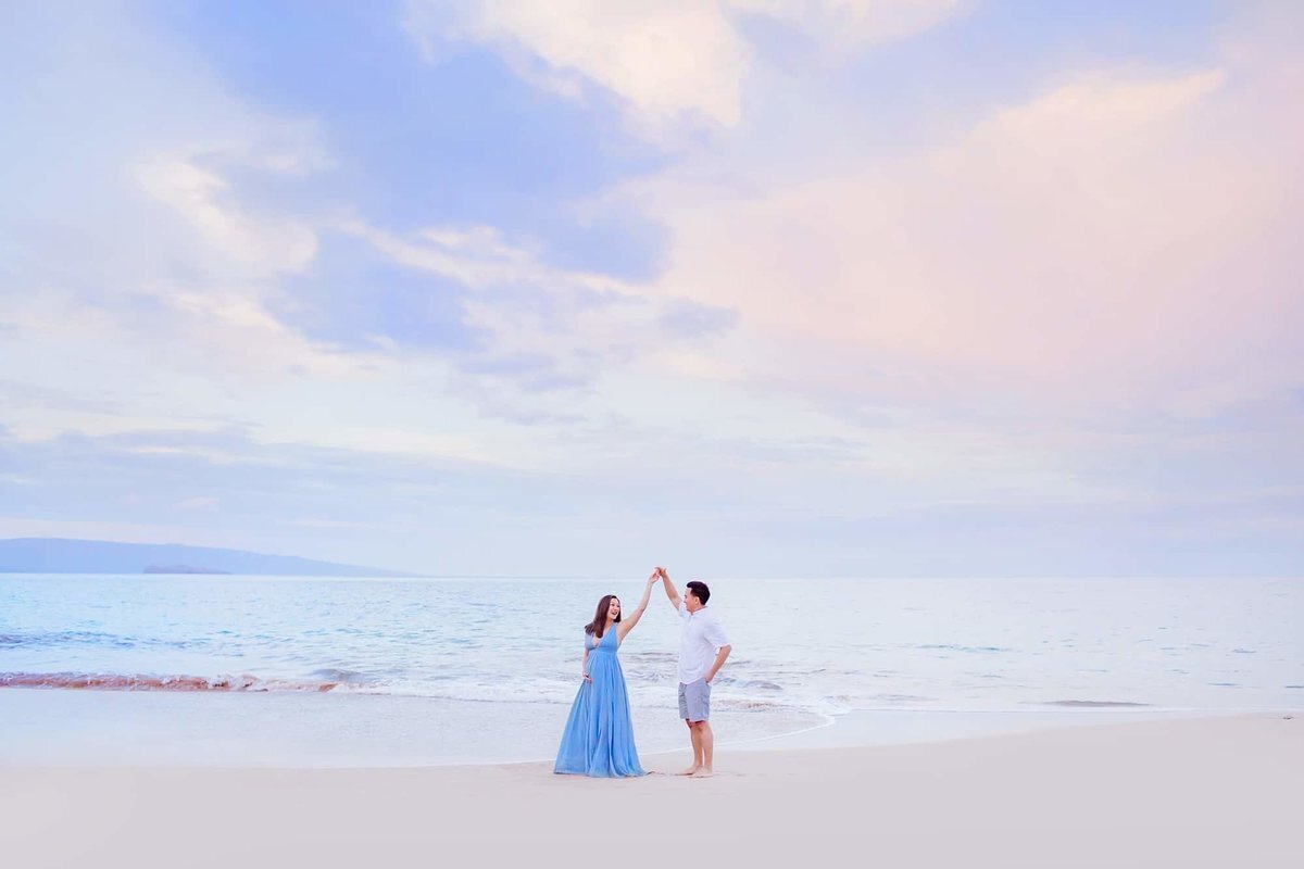Couple twirling at sunrise on Maui while photographed by Love + Water