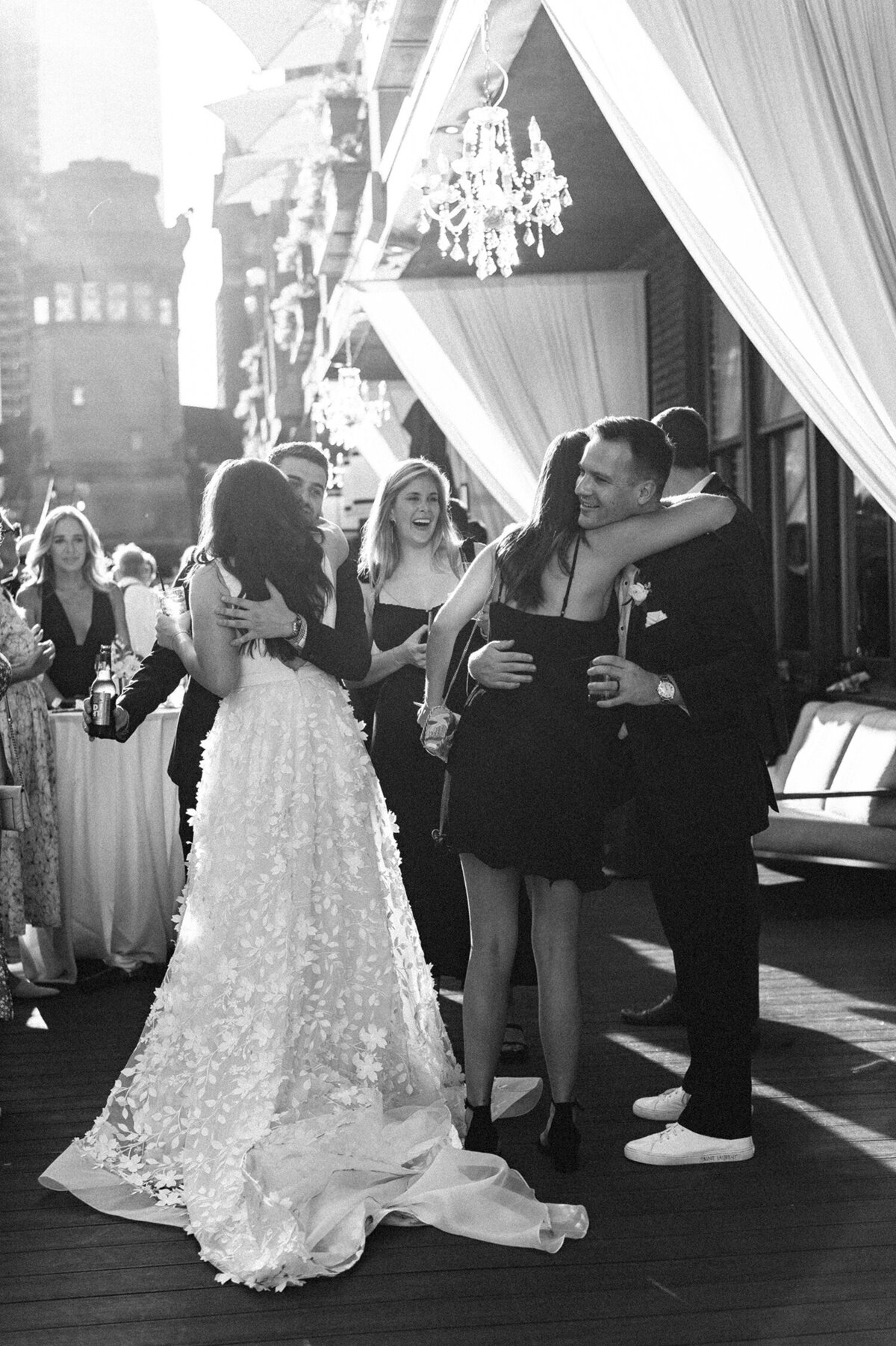 Wedding guests hugging and celebrating on an outdoor terrace