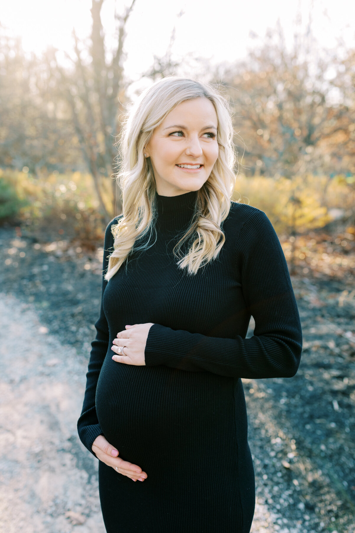 An expectant mother smiles during a maternity session at Ault Park.