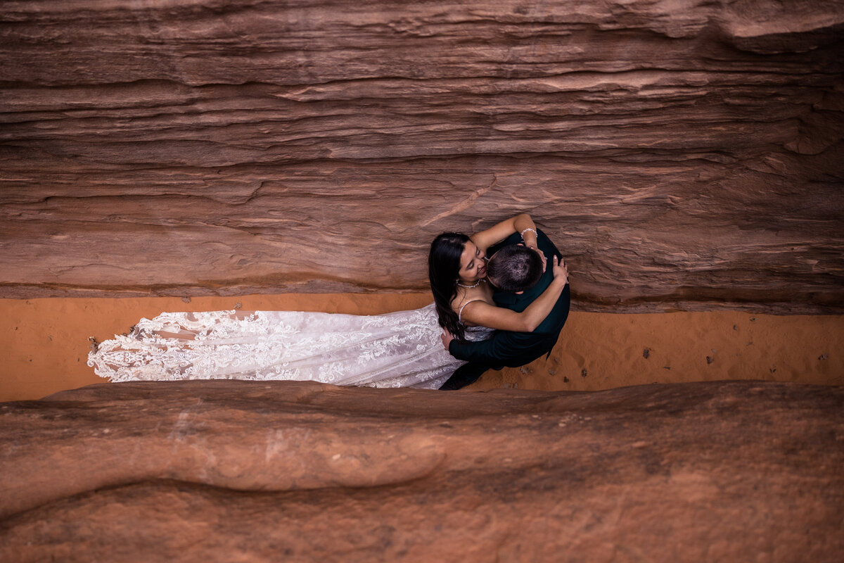 bride and groom kissing in slot canyon