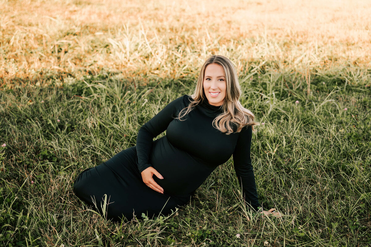 Springfield MO maternity photogrpaher Jessica Kennedy of The Xo Photography captures pregnant mom sitting on grass smiling