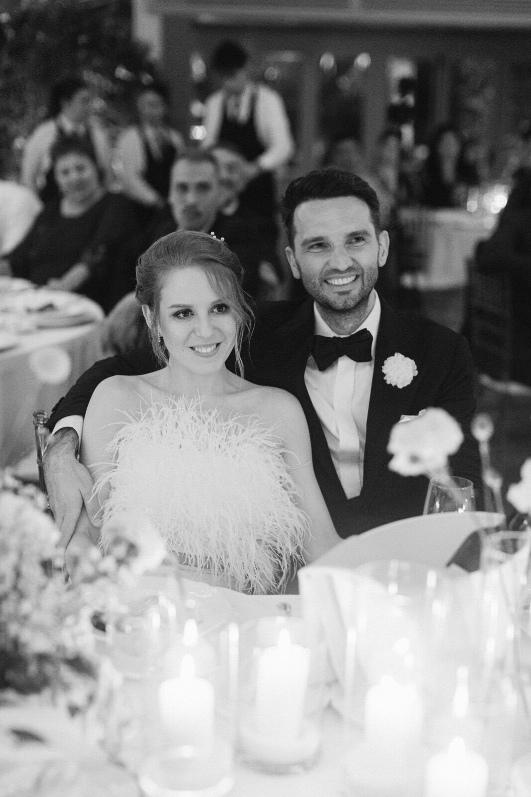 Bride and groom seated together at elegant candlelit dinner reception – timeless Italy wedding moment.
