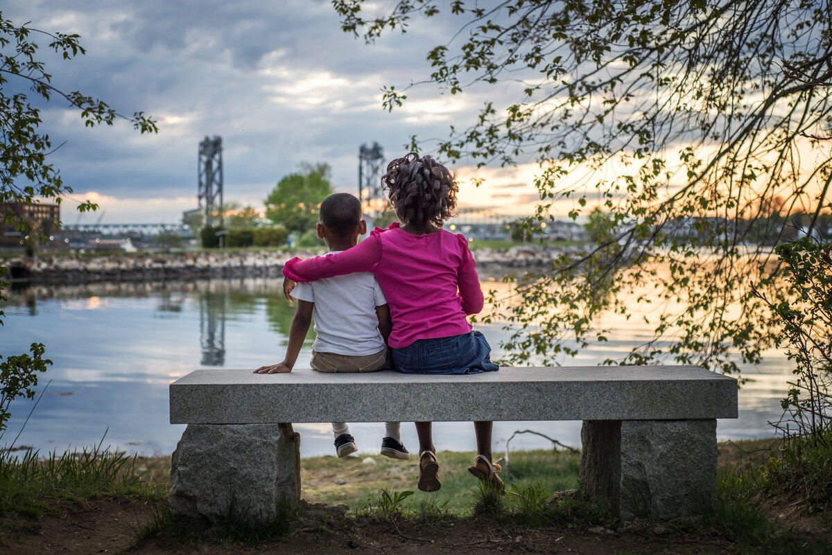 Portrait of siblings sitting on a bench in Portsmouth Looking at the sunset