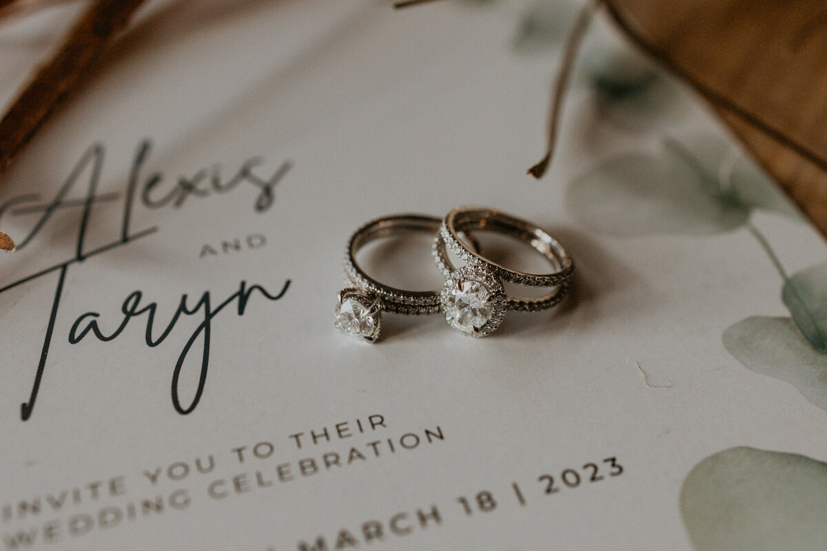 flatlay of a LGBTQ+ couples wedding details and jewelry