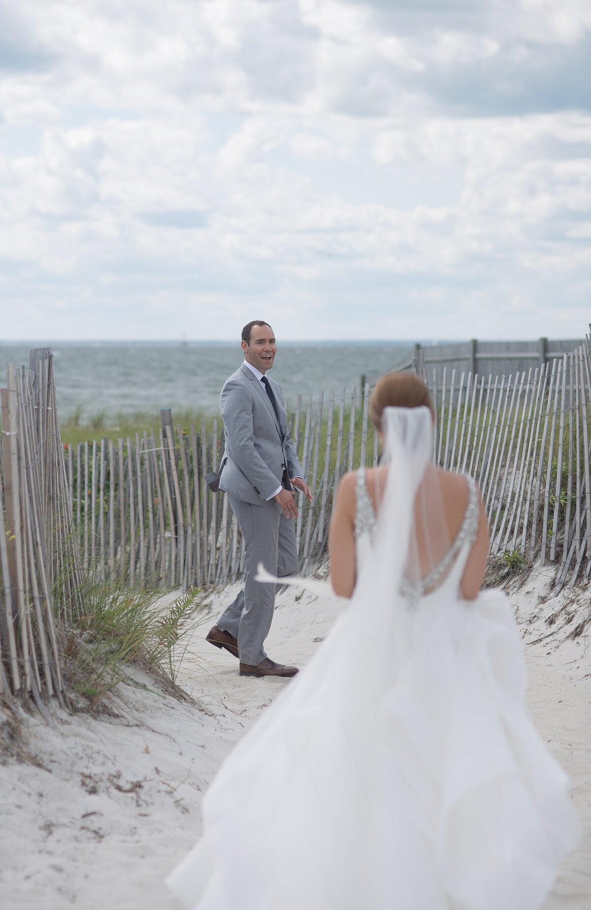 Groom sees Bride on wedding day and reacts with a smile.