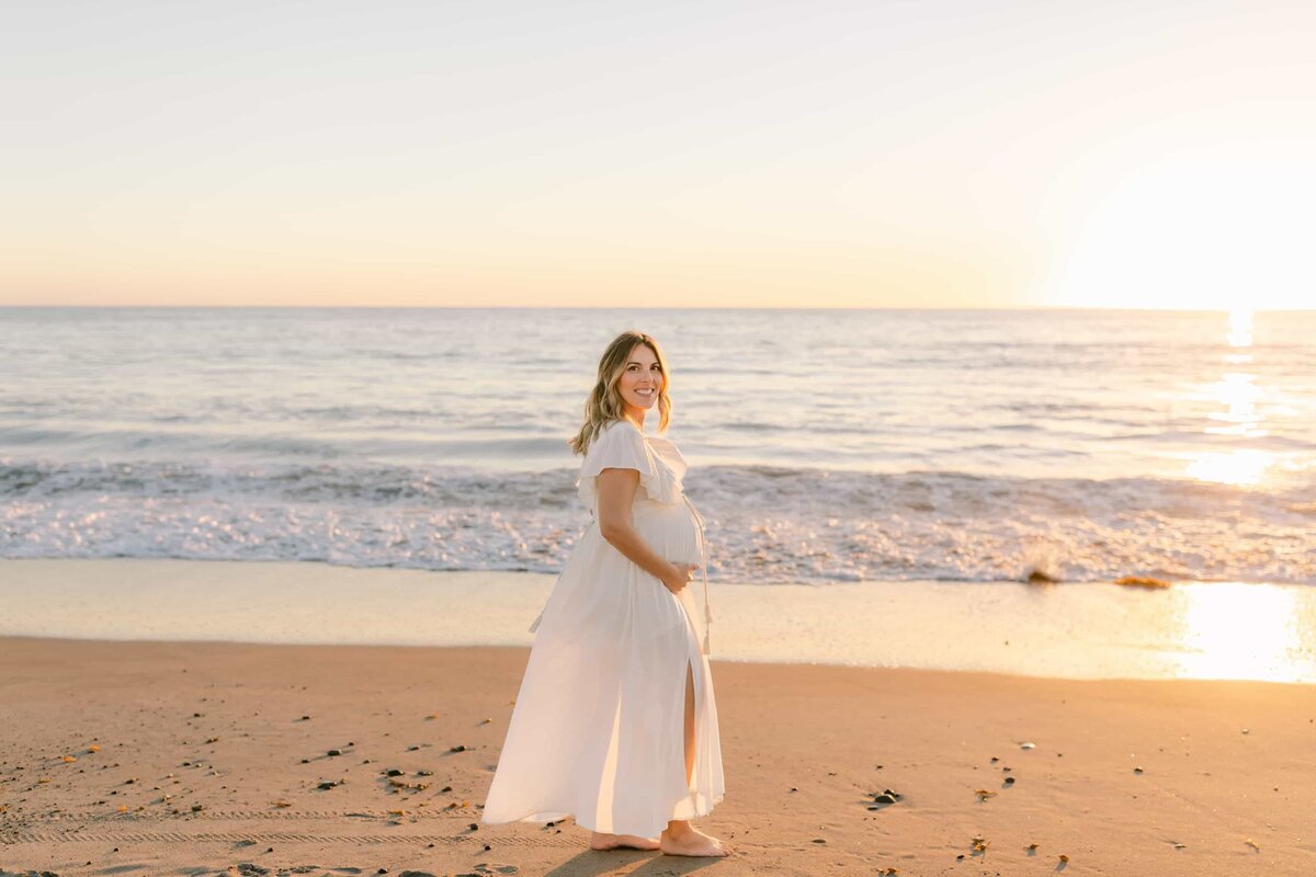 Orange County Maternity Photographer - pregnant women at sunset walking along the shore