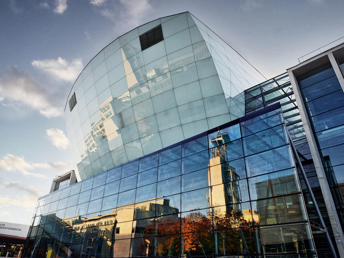 Architekturfotografie einer Glasfassade im Kulturbezirk St. Pölten mit markanten Spiegelungen – moderne Bildsprache für Architektur, Kultur und Unternehmenskommunikation in Österreich