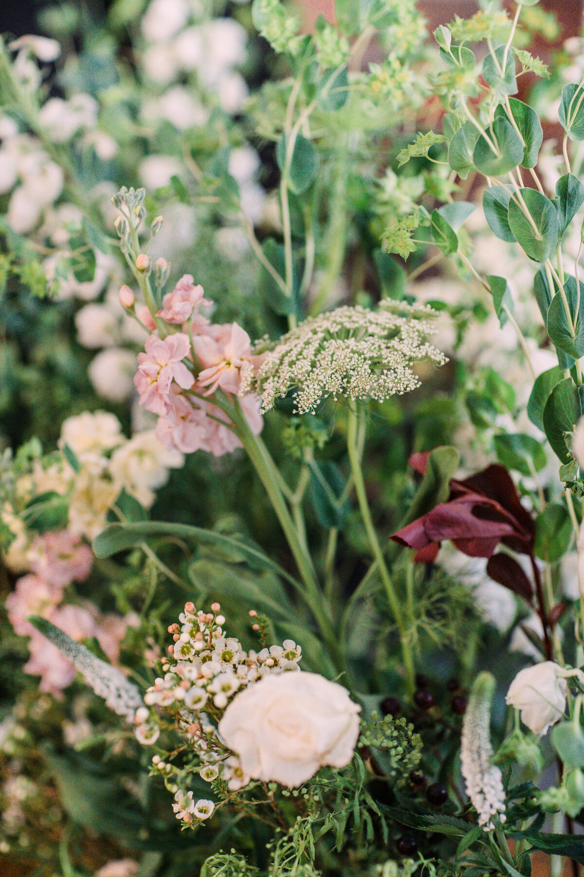 White waxflower, queen anne's lace, spray roses, garden roses, peach stock flower, and greenery for wedding ceremony