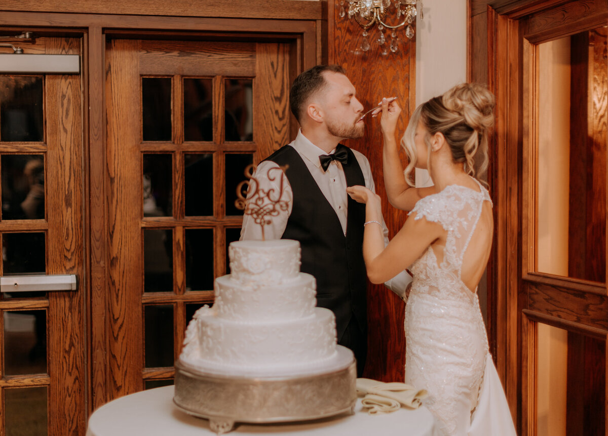 bride-feeding-the-groom-wedding-cake-saint-clements-castle