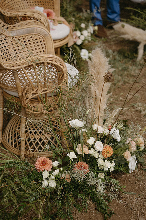 Fauteuil en rotin et composition florale pour une cérémonie de mariage en Côtes d'Armor en bretagne.