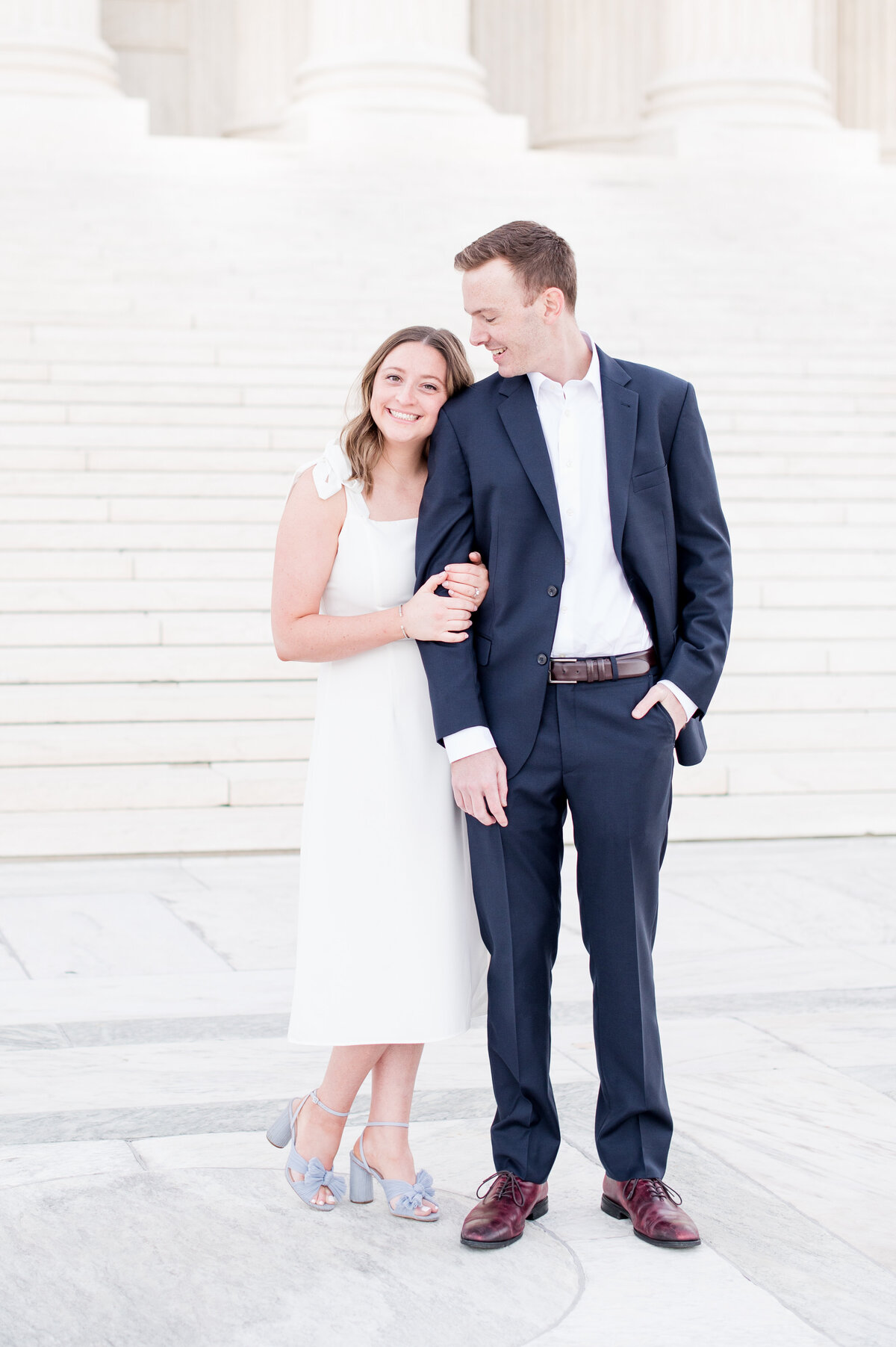 couple on marble steps white dress and blue suit