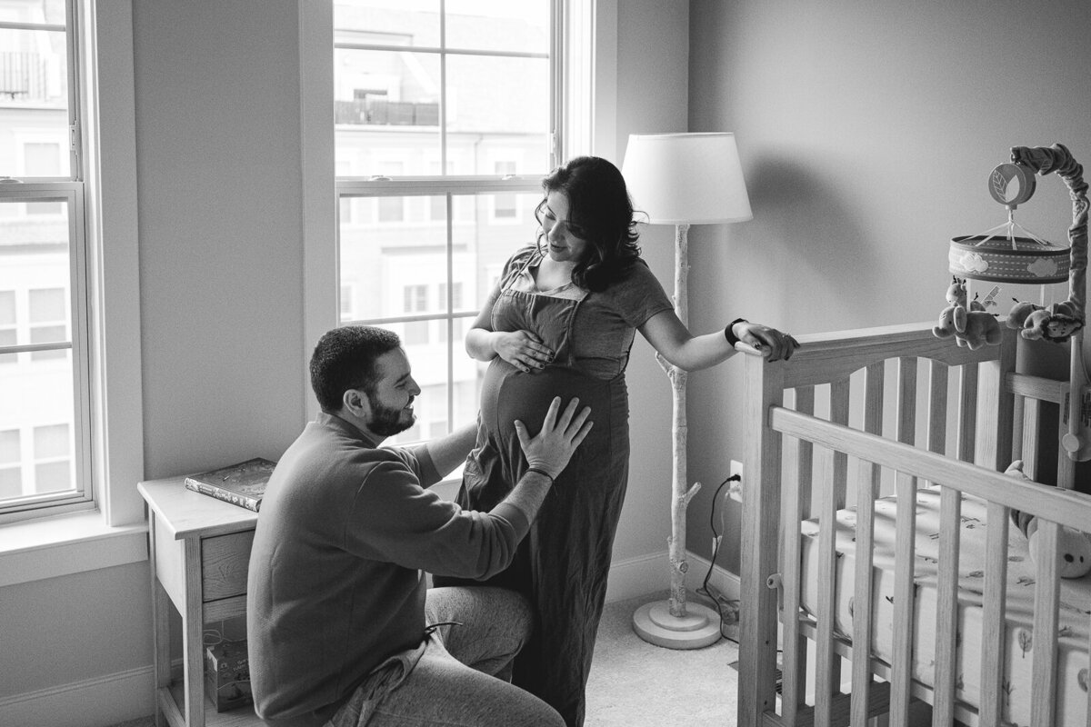 Pregnant mother and partner standing in baby's nursery