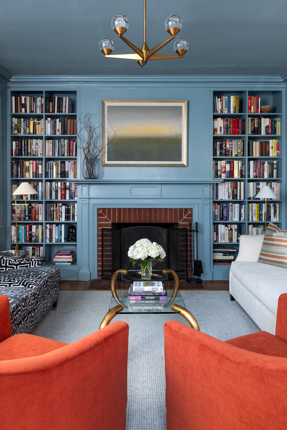 Elegant living room featuring a fireplace, built-in bookshelves filled with books and decor, and comfortable seating with a central coffee table