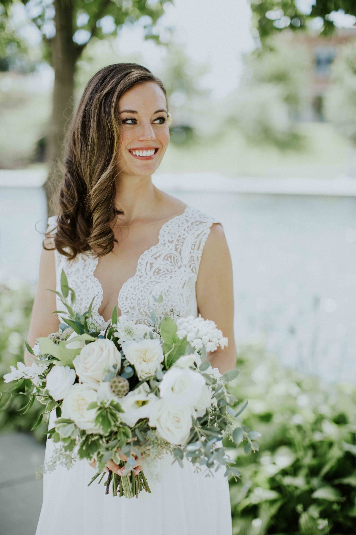 Bride smiles while holding bouquet in Indianapolis wedding