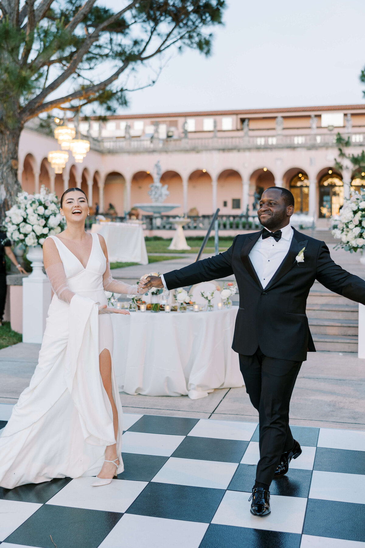 Bride and groom holding hands at outdoor wedding party
