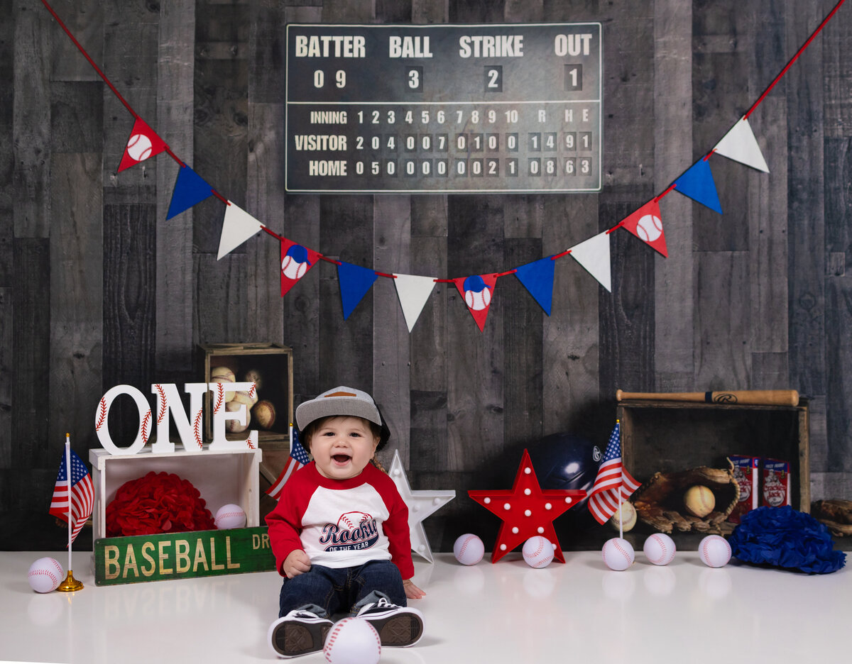 Baseball-themed first birthday cake smash with red, white, and blue decor – Cake smash photography in Waldwick NJ studio