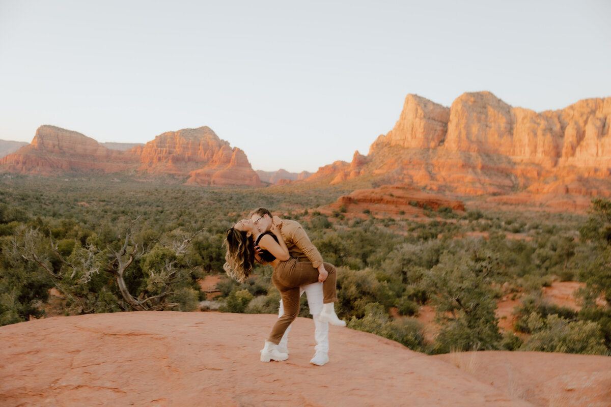 couple posing on mountain top of desert